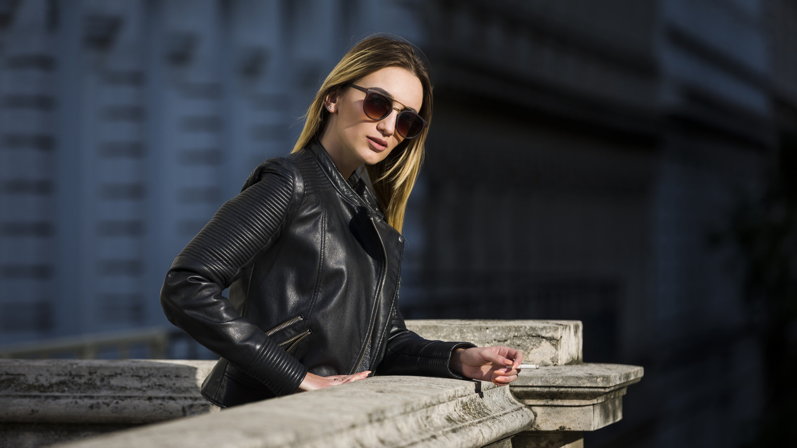 Woman wearing sunglasses and a black leather jacket