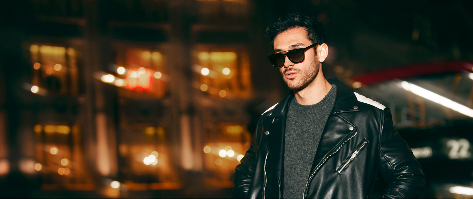 Man wearing a black leather jacket and sunglasses